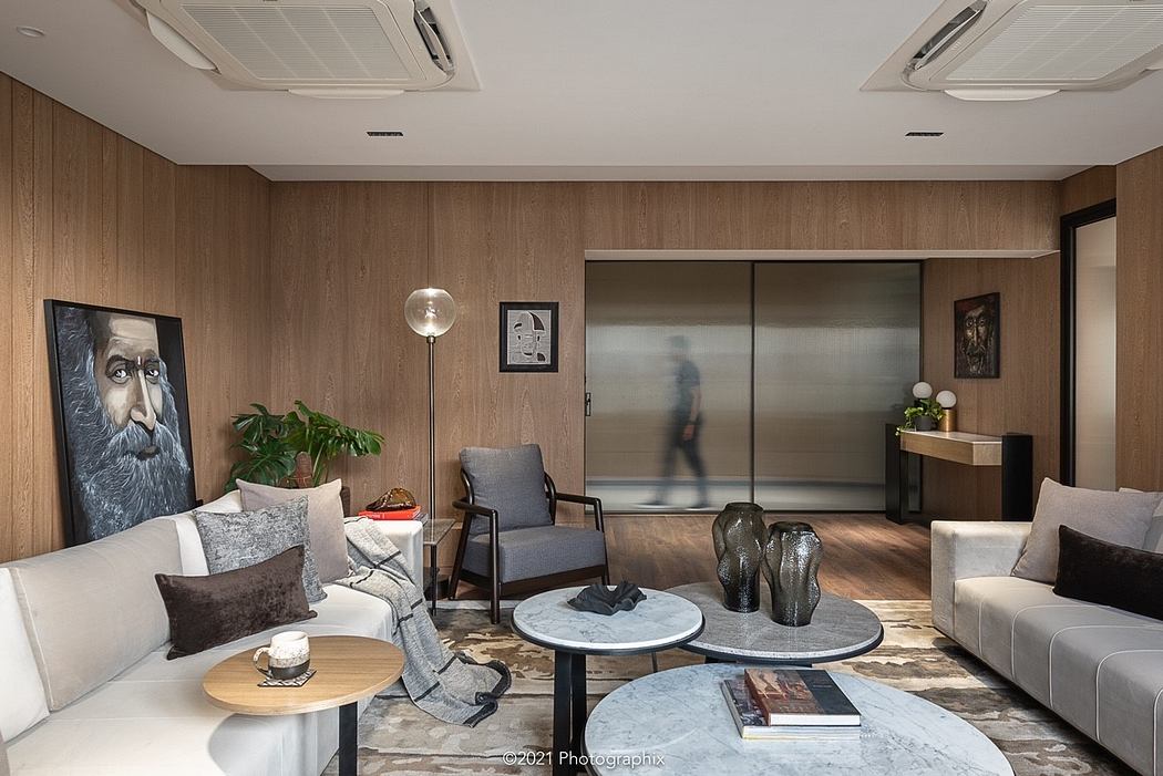Stylish living room with modern furniture, artwork, and natural wood paneling.