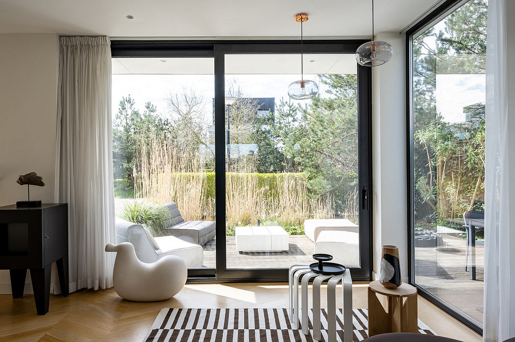 Stylish modern living room with large windows, contemporary furniture, and sleek lighting.