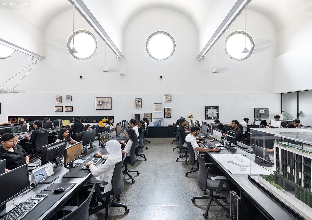 Sleek, modern workspace with circular lighting fixtures, industrial furniture, and organized workstations.