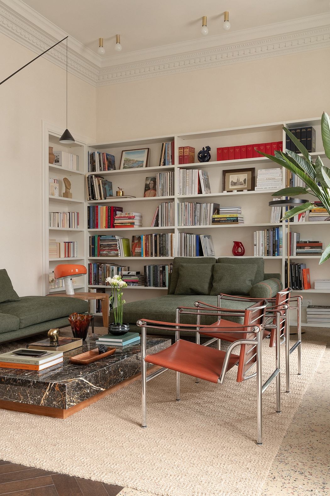 Elegant living room with intricate crown molding, built-in bookshelves, and stylish furniture.