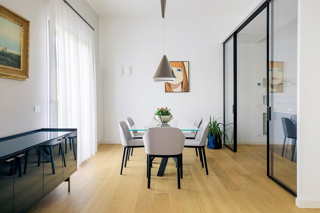 Modern, minimalist dining room with glass table, upholstered chairs, artwork, and lighting fixture.