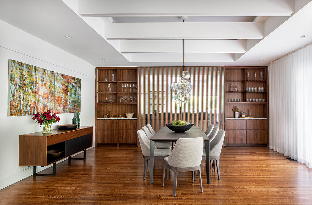 Sophisticated dining room with wooden built-in shelving, ornate chandelier, and vibrant abstract artwork.