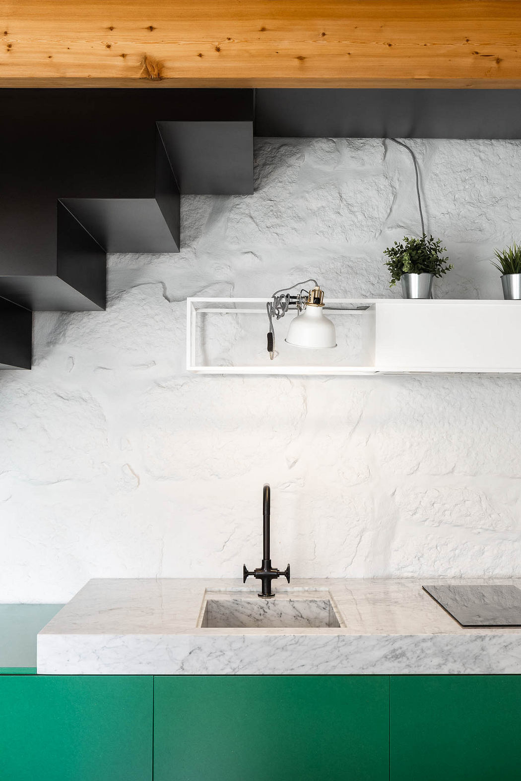 Sleek, modern kitchen with white marble countertops, recessed lighting, and green cabinetry.