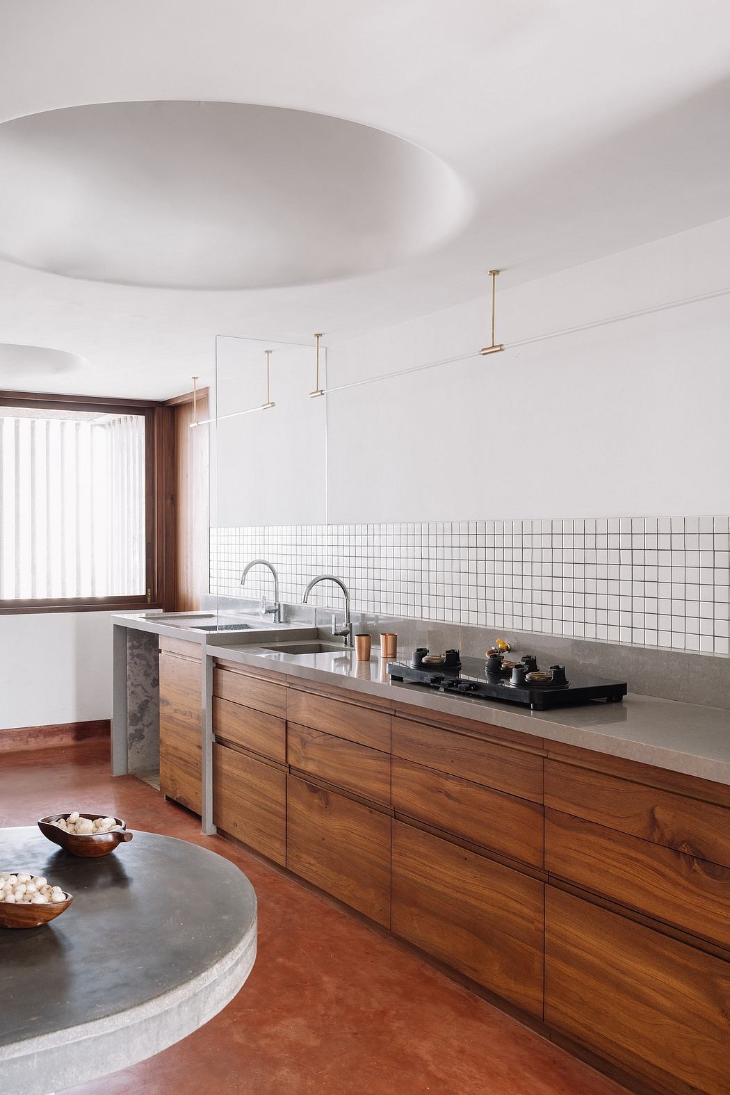 A modern kitchen with wooden cabinets, tiled backsplash, and minimalist lighting fixtures.