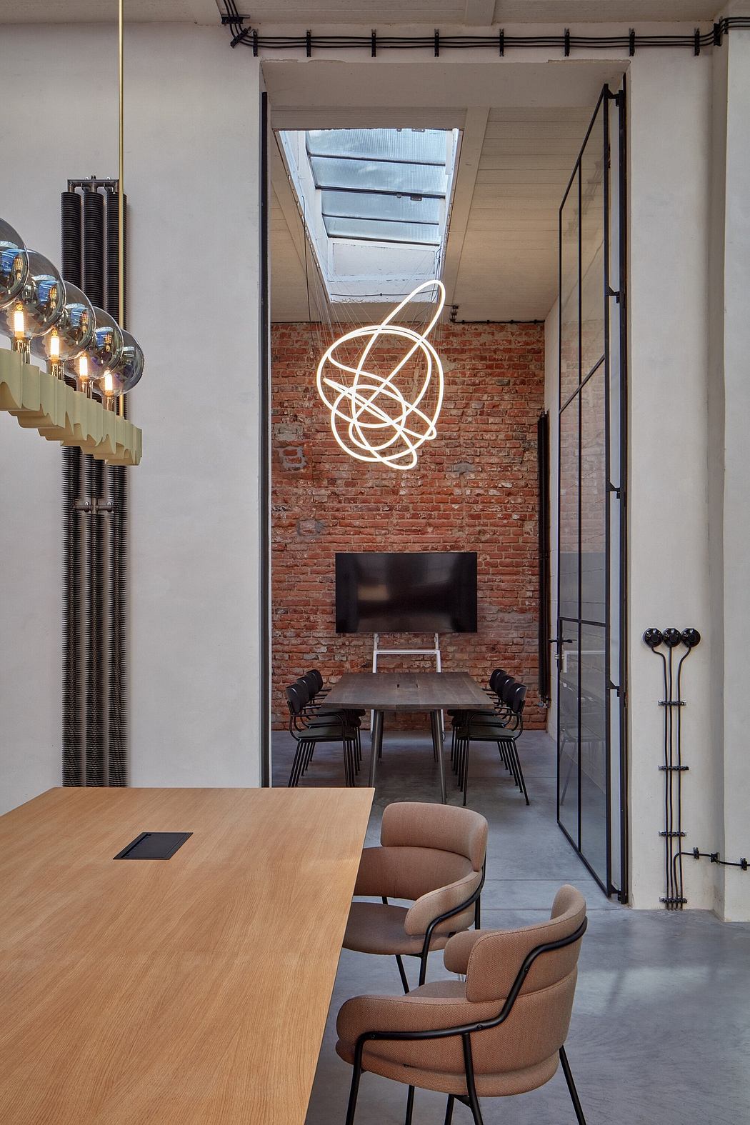 Minimalist office space with exposed brick, neon lighting, and modern furniture.