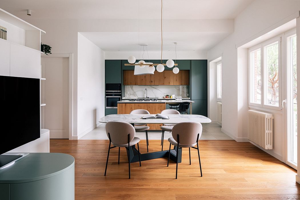 Modern kitchen and dining area with wooden furniture, dark green cabinets, and pendant lights.