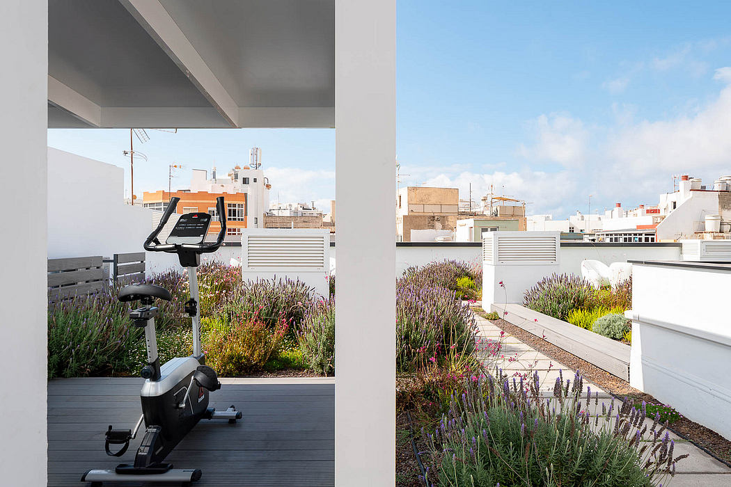 Modern and minimalist exercise space with a cityscape view and lush landscaping.