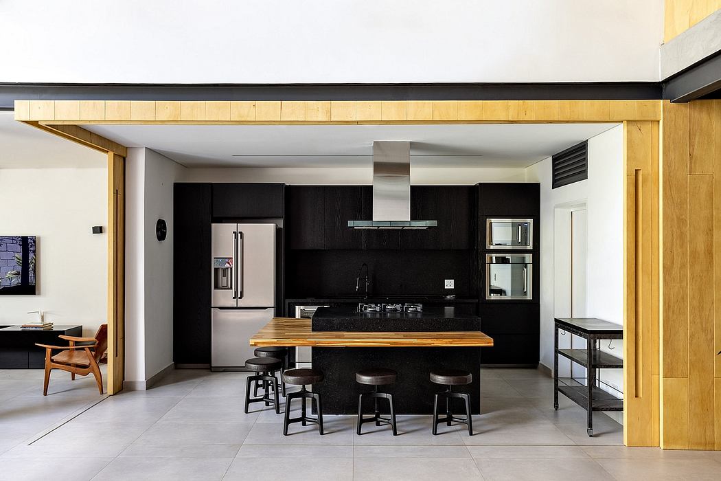 Sleek, modern kitchen with black cabinetry, wood accents, and an open floor plan.