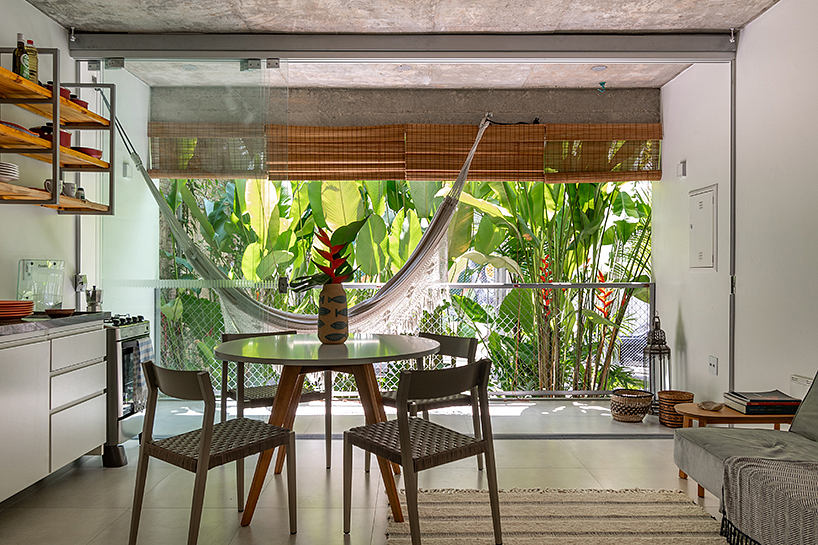 Modern, open-concept living space with lush tropical views and minimalist furnishings.