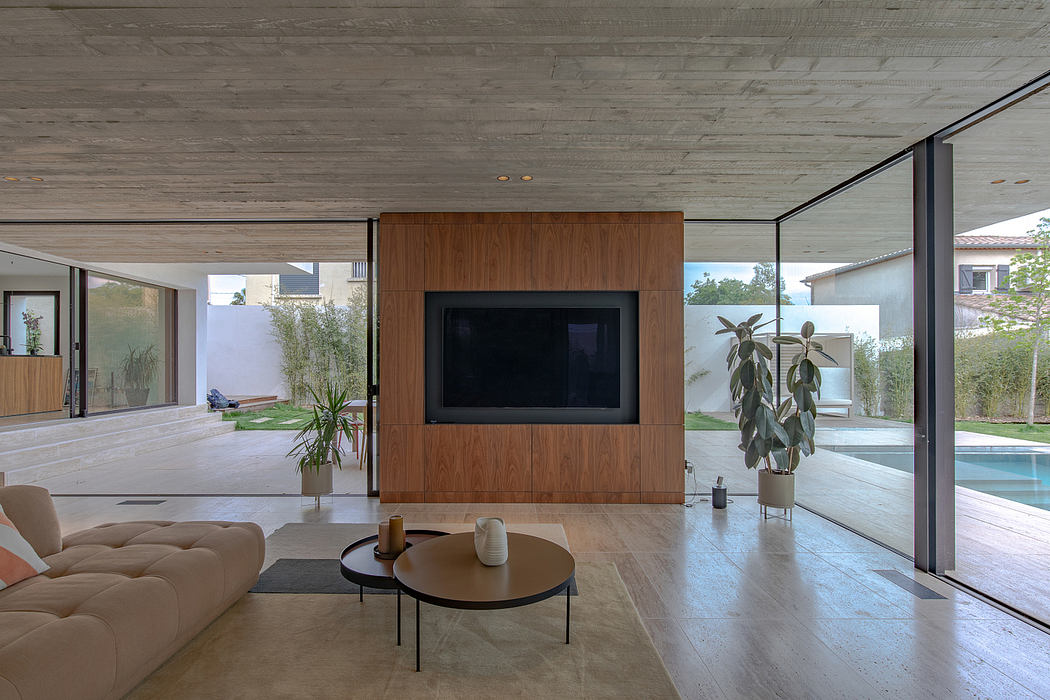 Spacious modern living room with wood paneling, concrete ceiling, and sliding glass doors.