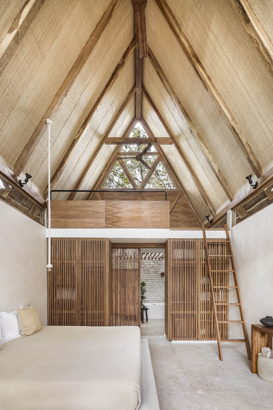 A spacious, open-concept interior with a soaring wooden ceiling, loft, and earthy tones.