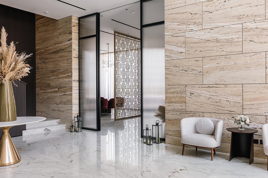 Modern luxury lobby with sleek marble flooring, textured wood paneling, and decorative glass dividers.