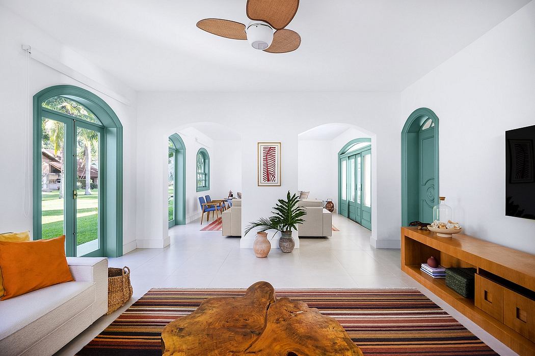 Spacious, bright living area with arched windows, warm wood accents, and statement fan.