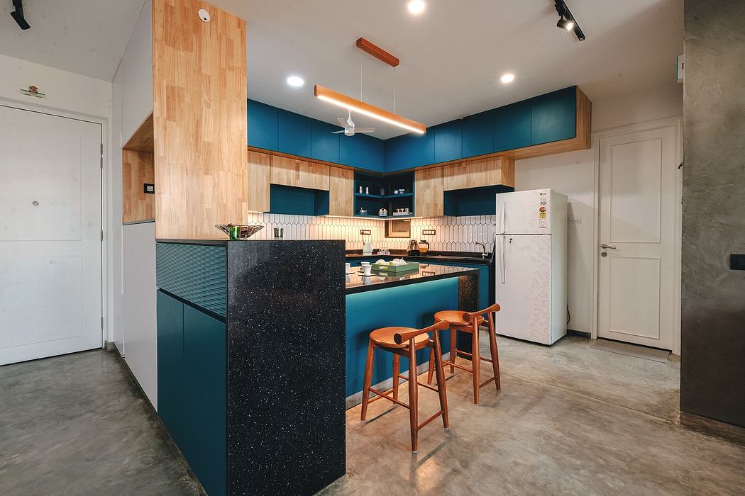 Modern kitchen with teal cabinets, wooden accents, and a sleek black countertop bar.
