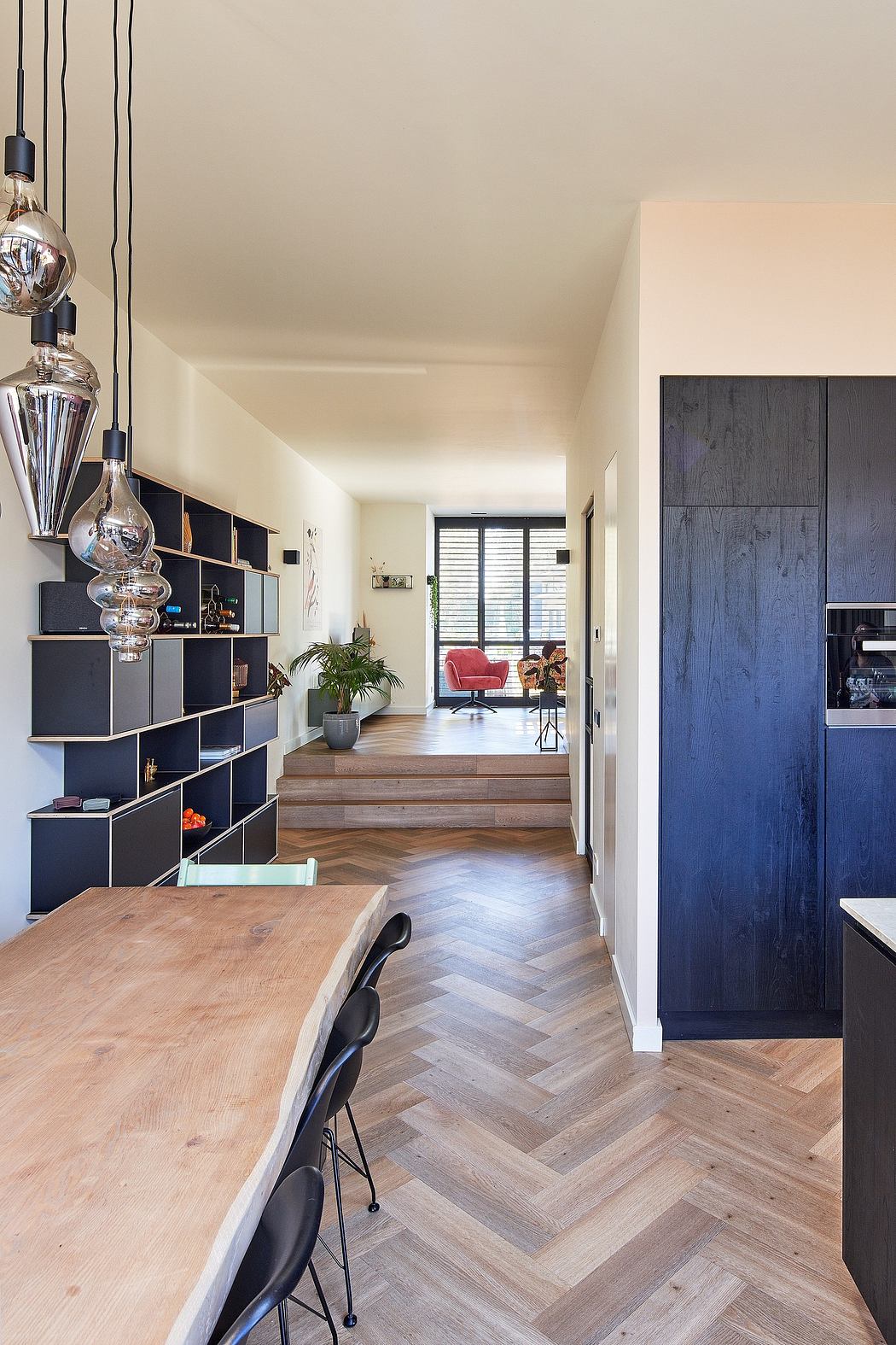 Sleek, modern interior with wood floors, built-in cabinetry, and hanging light fixtures.