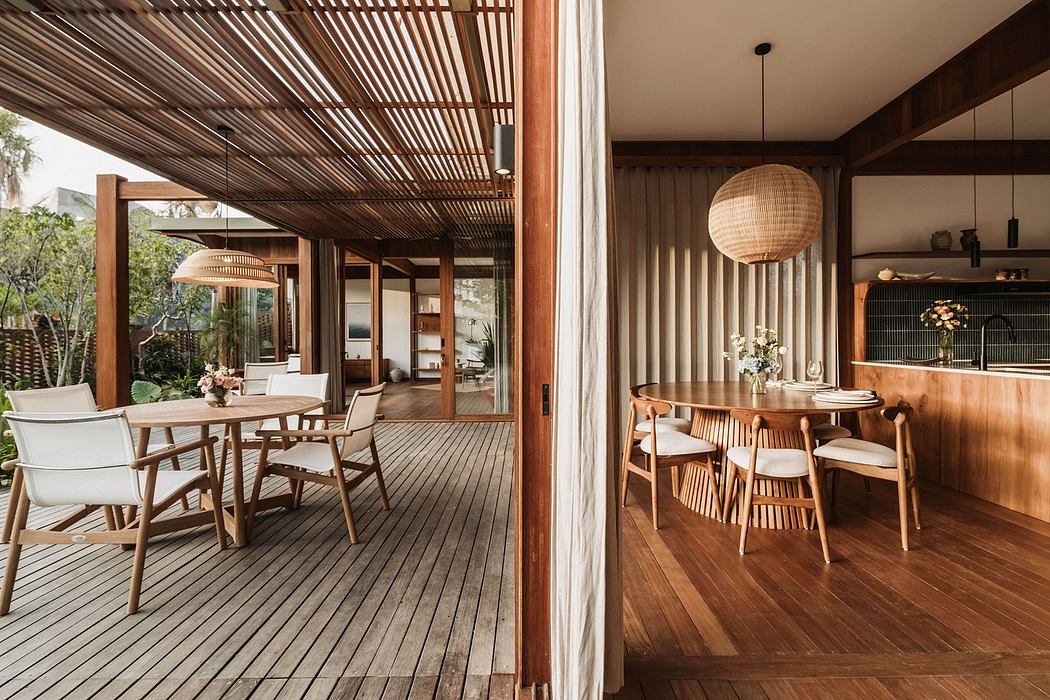 An open-plan dining and living area with a wooden, slatted ceiling and furniture.