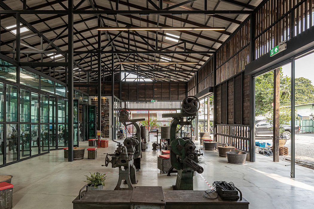 A spacious industrial warehouse with wooden beams, metal frames, and concrete floors.