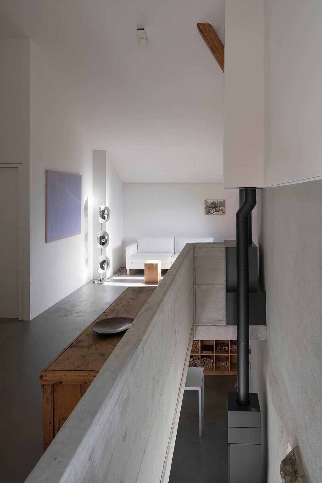 A minimalist interior design featuring concrete countertops, wooden accents, and a sleek fireplace.