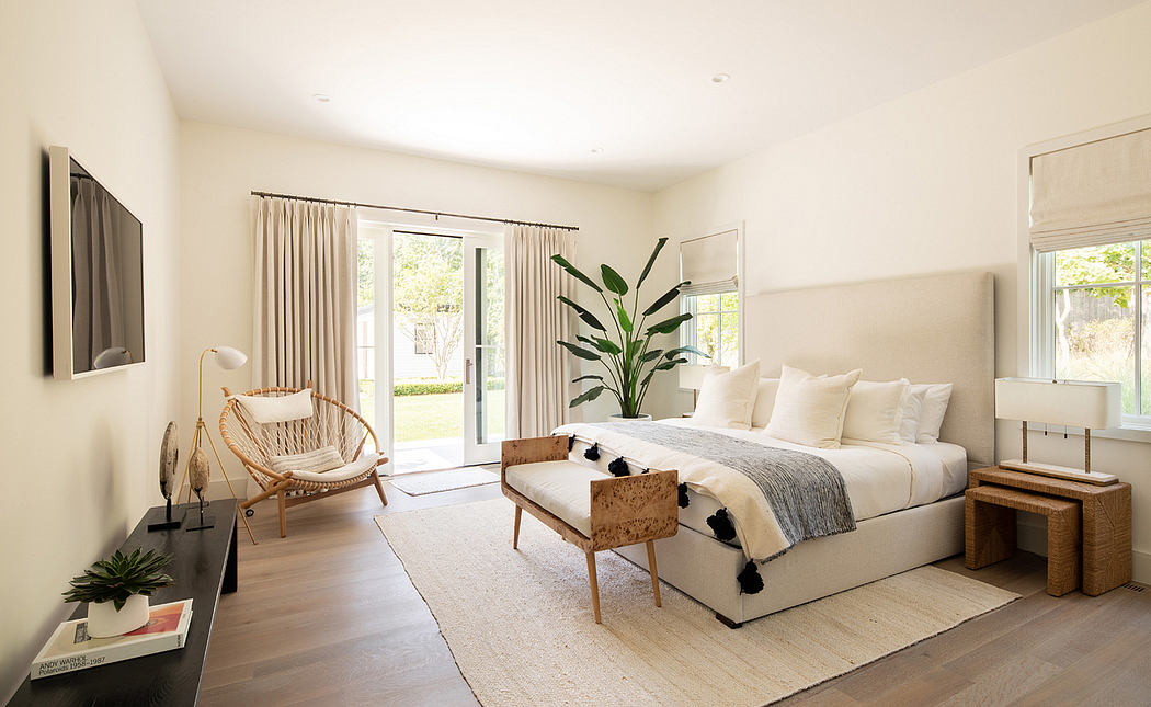 Spacious bedroom with plush bedding, textured rug, and natural light through sliding doors.