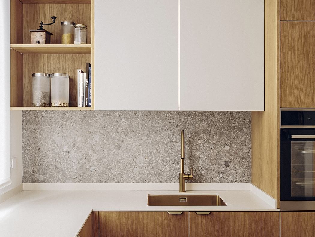Modern kitchen with wooden cabinets, gray stone backsplash, and brass faucet.