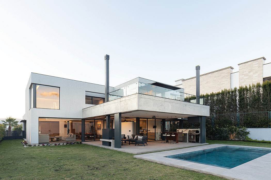 Modern, concrete and glass house with pool, patio, and surrounding landscaping.