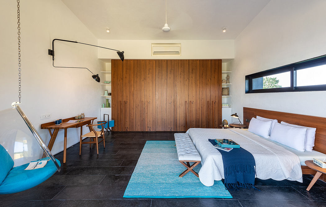 The image showcases a modern and cozy bedroom with wooden accents, a built-in wardrobe, and a workspace.