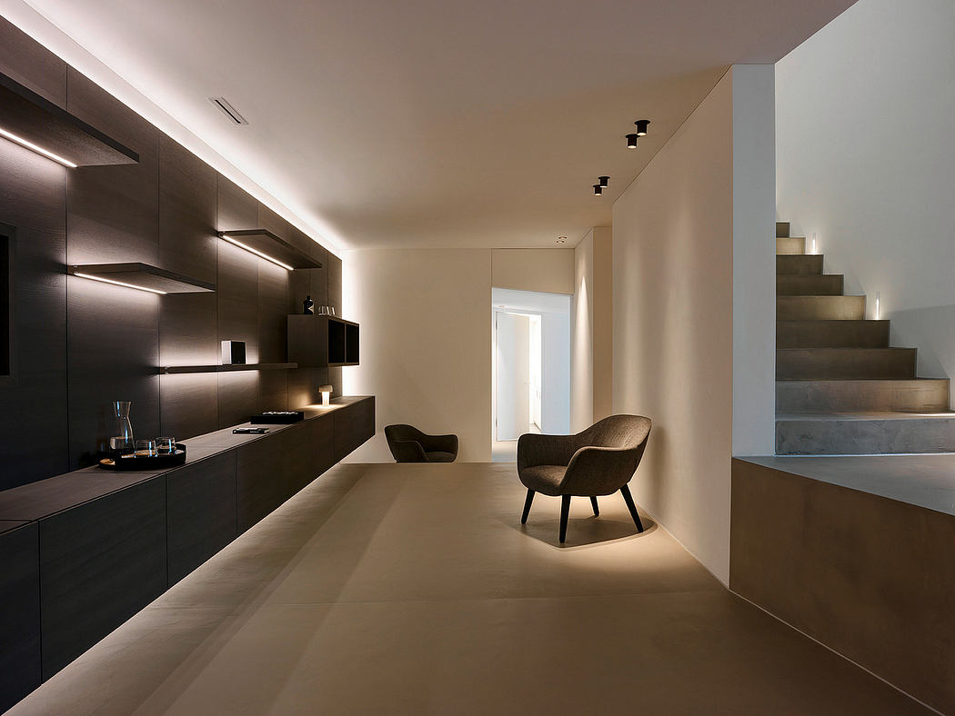 Sleek, modern kitchen with built-in cabinetry and minimalist furniture in an open-concept space.