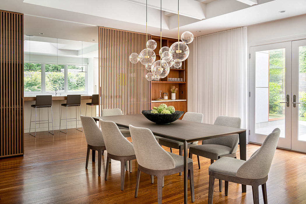 A modern, minimalist dining room with wooden paneled walls, a large glass chandelier, and contemporary furniture.