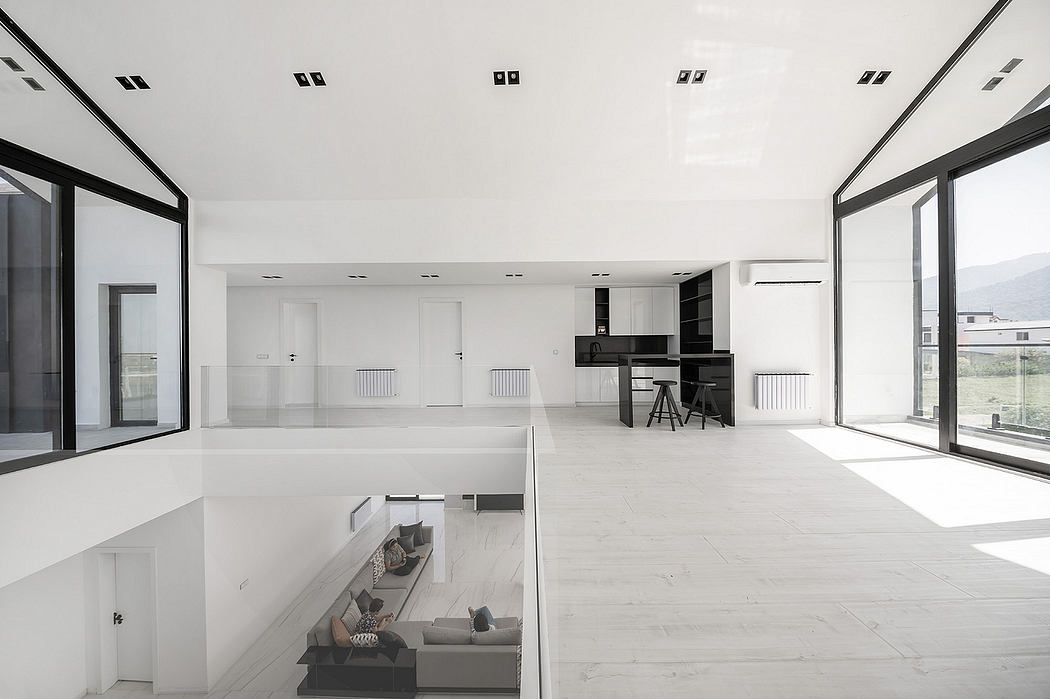 Spacious, minimalist interior with large windows, open floor plan, and sleek built-in furnishings.