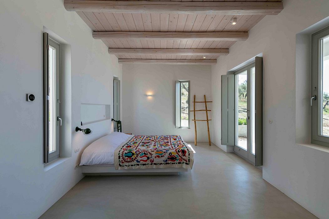 Rustic bedroom with exposed wooden ceiling beams, minimalist decor, and large windows.