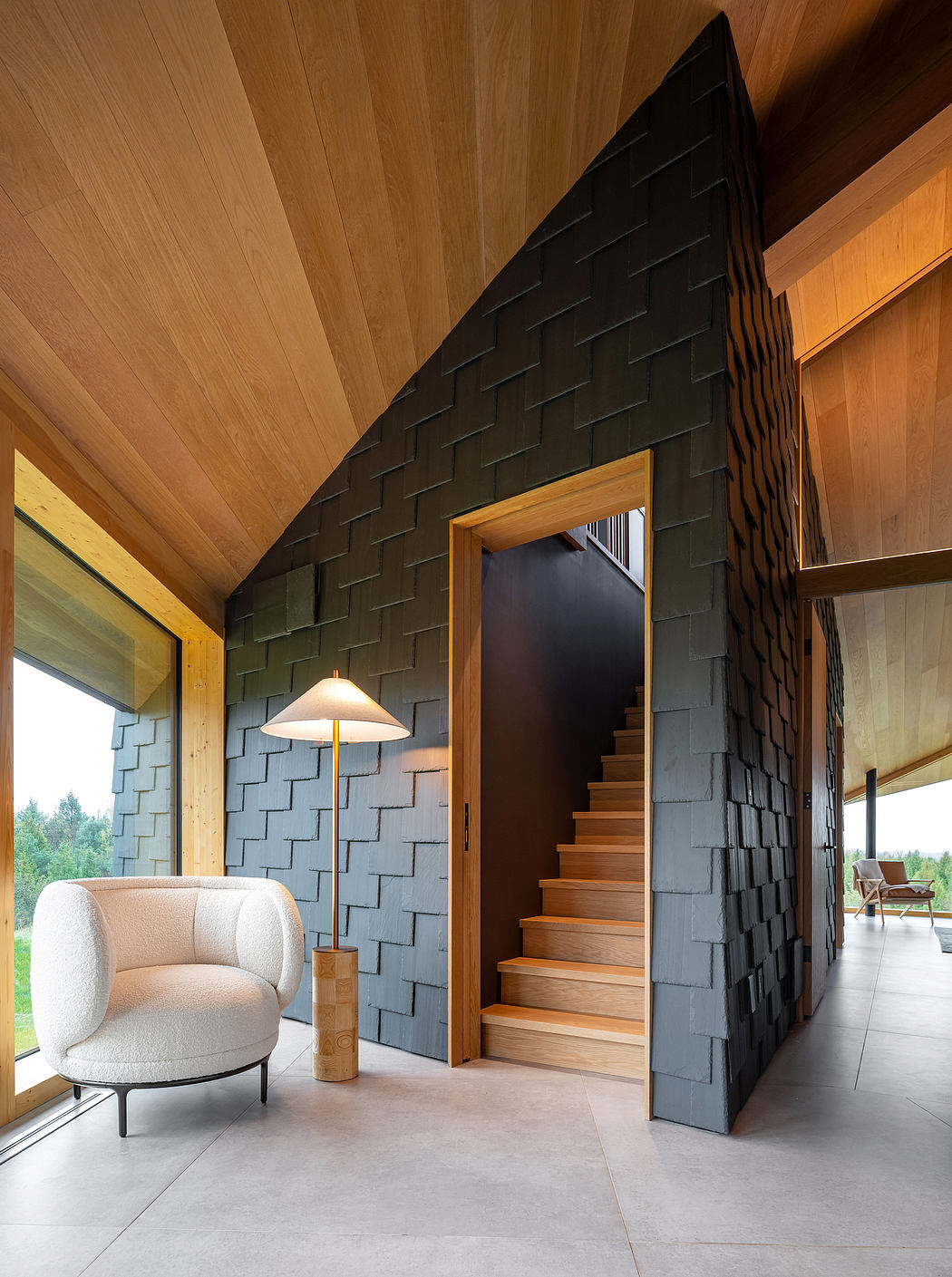 A modern, cozy interior with a unique brick wall, wooden accents, and a statement staircase.