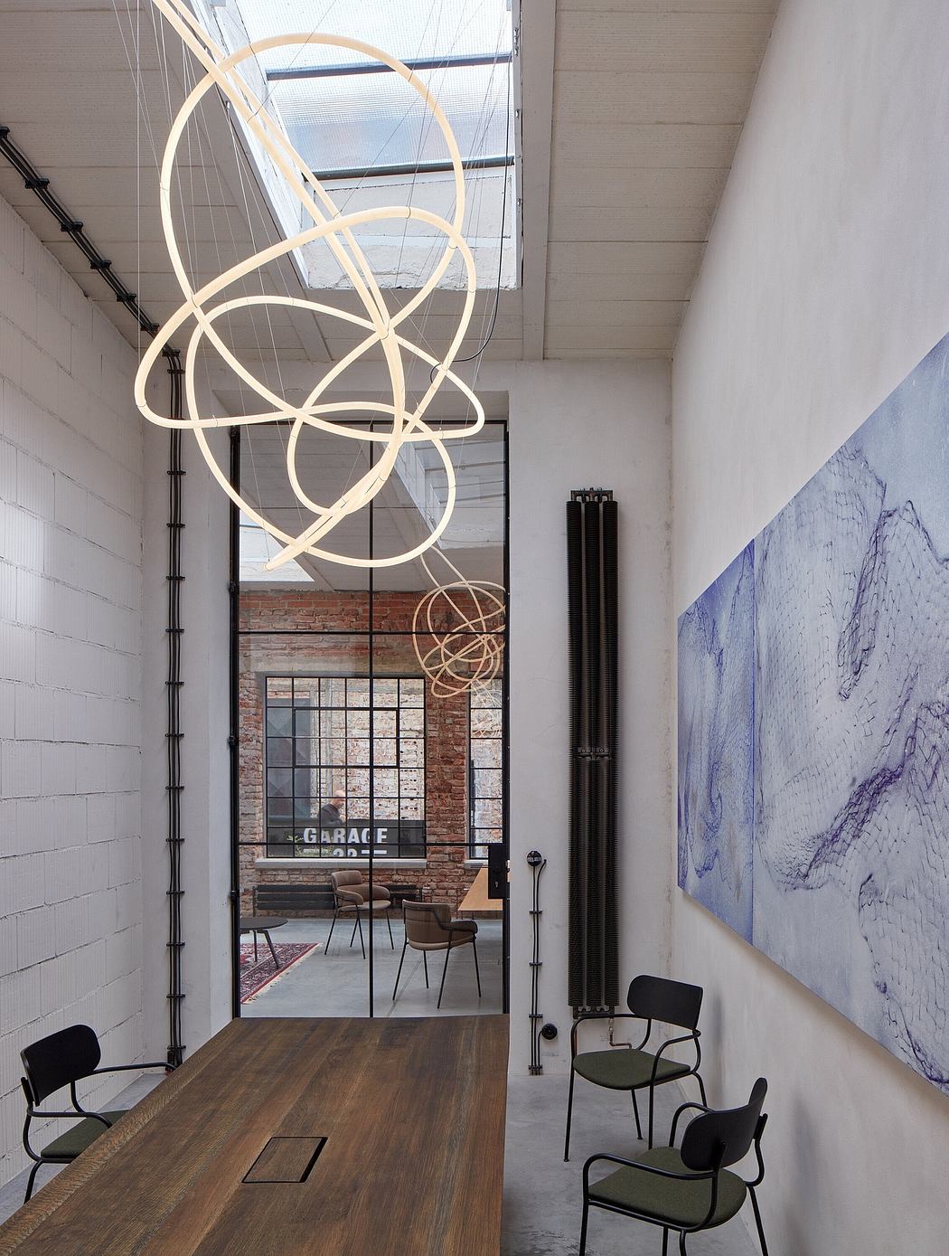 A modern, minimalist interior design with suspended lighting, brick walls, and abstract art.