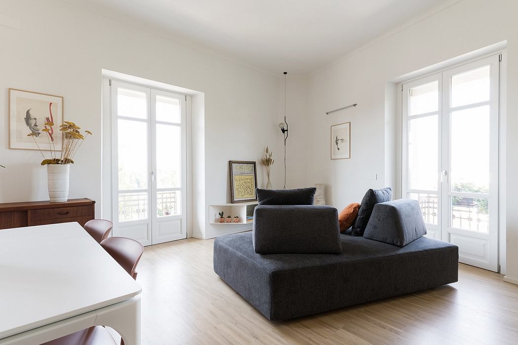 Bright, modern living room with sleek gray sofa, wooden furniture, and French doors.