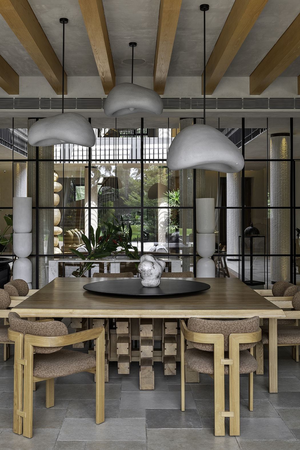 Sleek modern design with wood beams, concrete walls, and mushroom-shaped pendant lights.