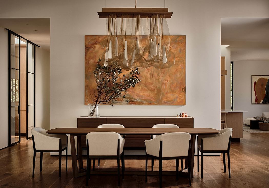 Warm-toned, contemporary dining room features abstract artwork, pendant lighting, and wood furniture.