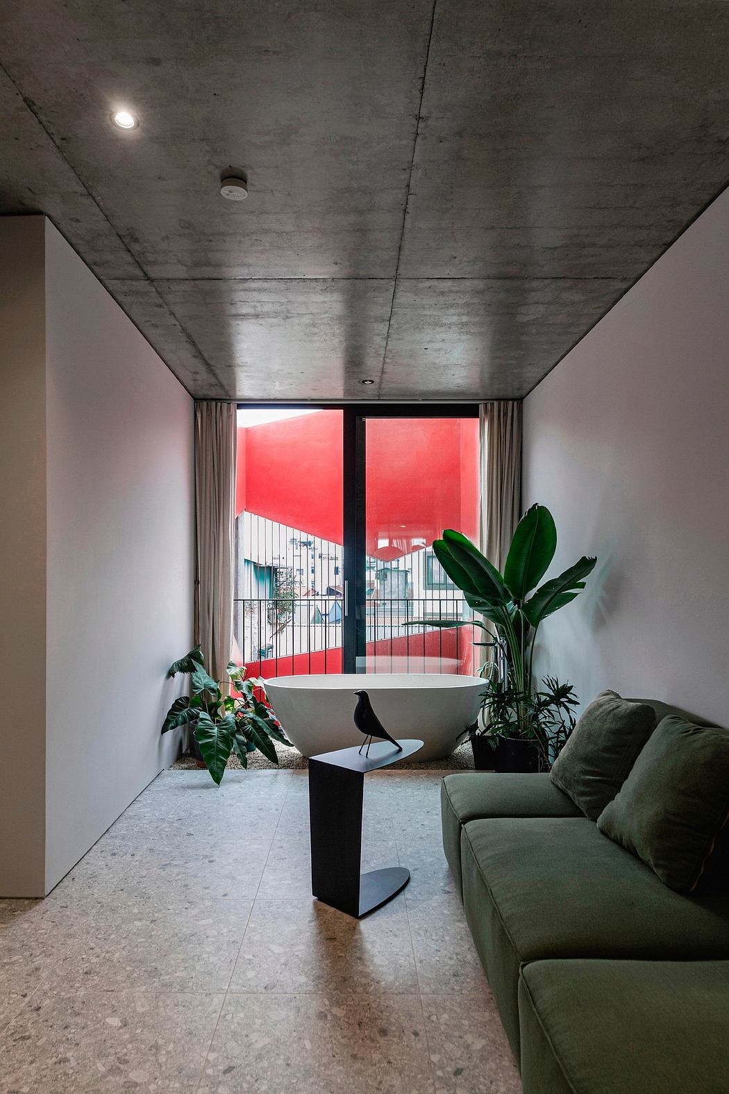 Minimalist bathroom with a freestanding tub, lush greenery, and concrete finishes.