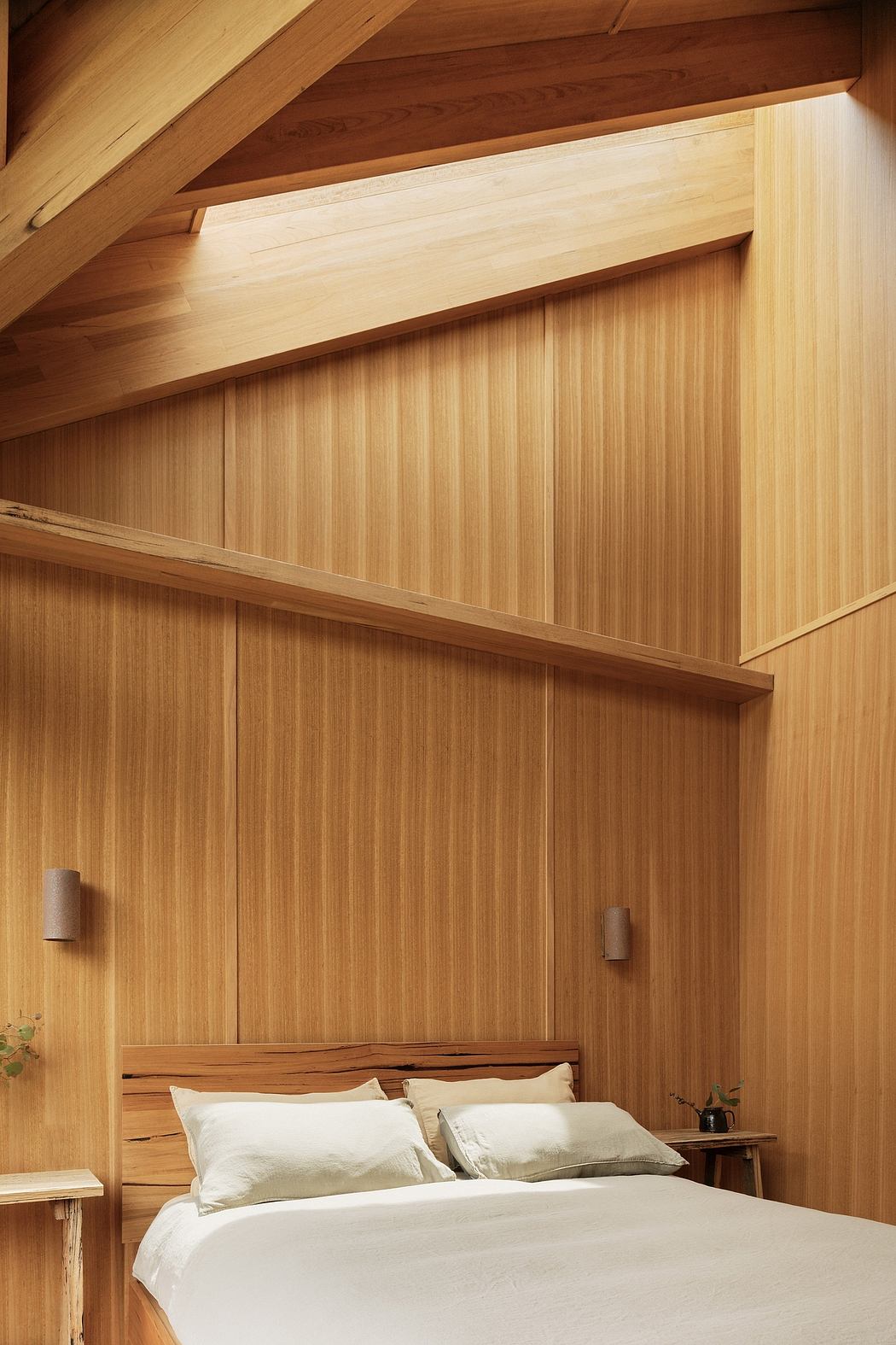 A cozy bedroom with warm, wooden paneled walls and a sleek, minimalist design.