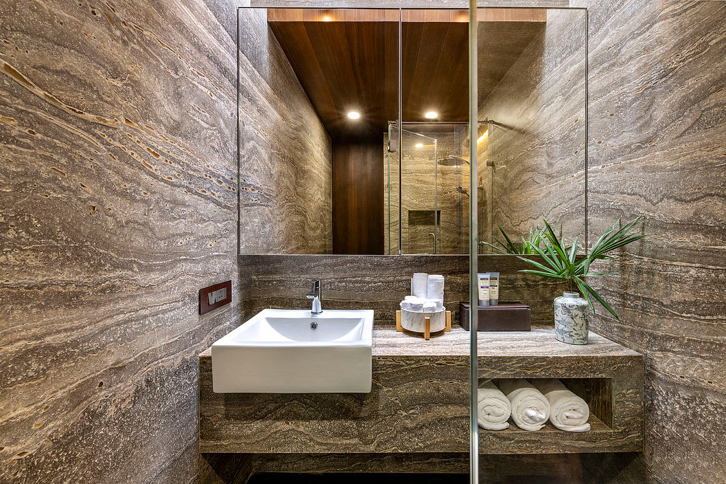 Stylish bathroom with warm-toned marble walls, modern vanity, and recessed lighting.