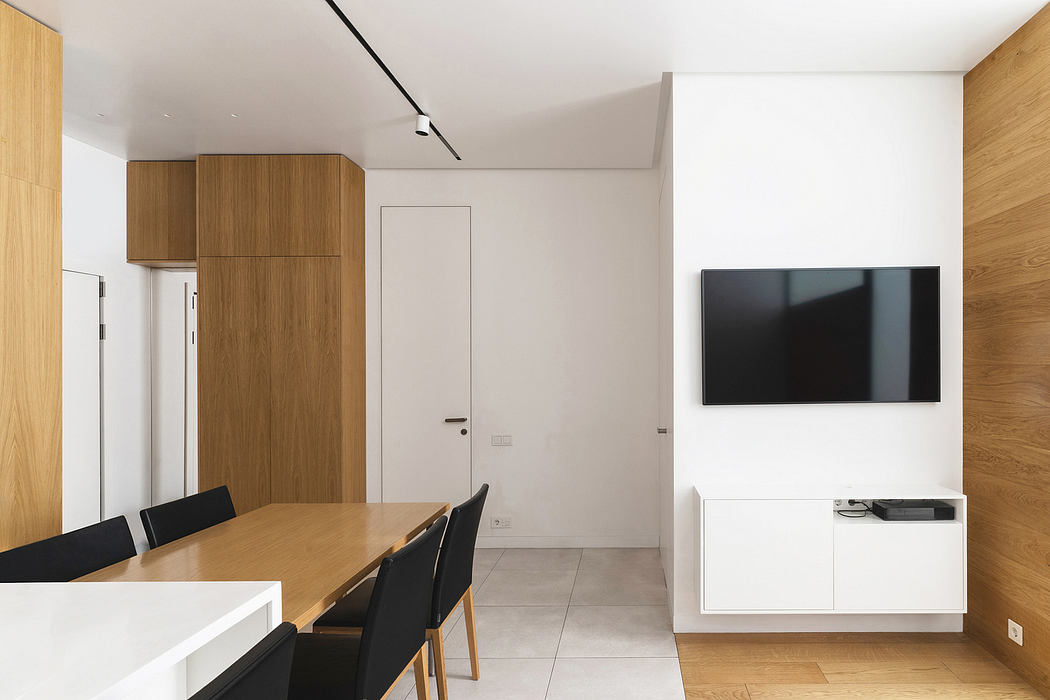Minimalist modern interior with wood paneling, white walls, and a large TV.