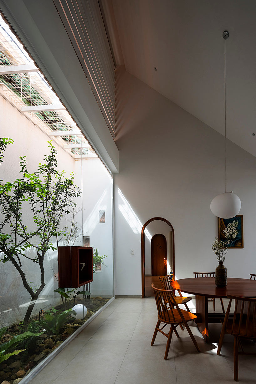 A serene indoor garden with a wooden dining set and architectural details.
