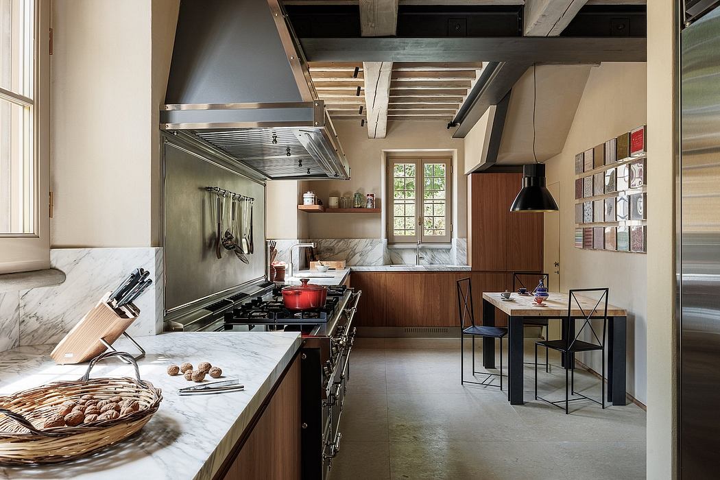 A rustic kitchen with wooden beams, marble countertops, and a mix of modern and vintage appliances.
