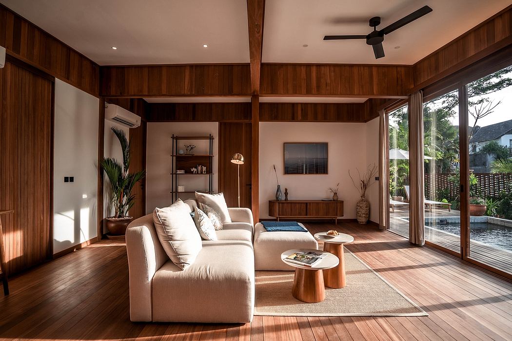 Cozy living room with wooden walls, high ceilings, and large sliding glass doors overlooking a pool.