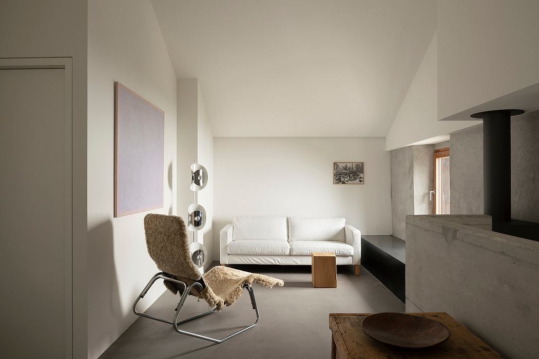 Minimalist living room with white sofa, shag armchair, and concrete fireplace.