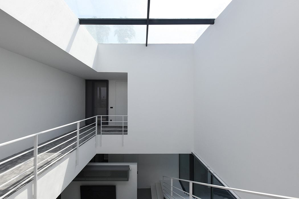 Minimalist design with clean lines, contrasting black and white, and a skylight creating an airy ambiance.