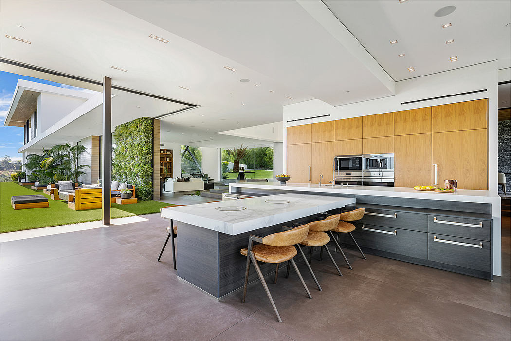 Spacious, contemporary kitchen with sleek gray cabinets, marble countertop, and modern appliances.