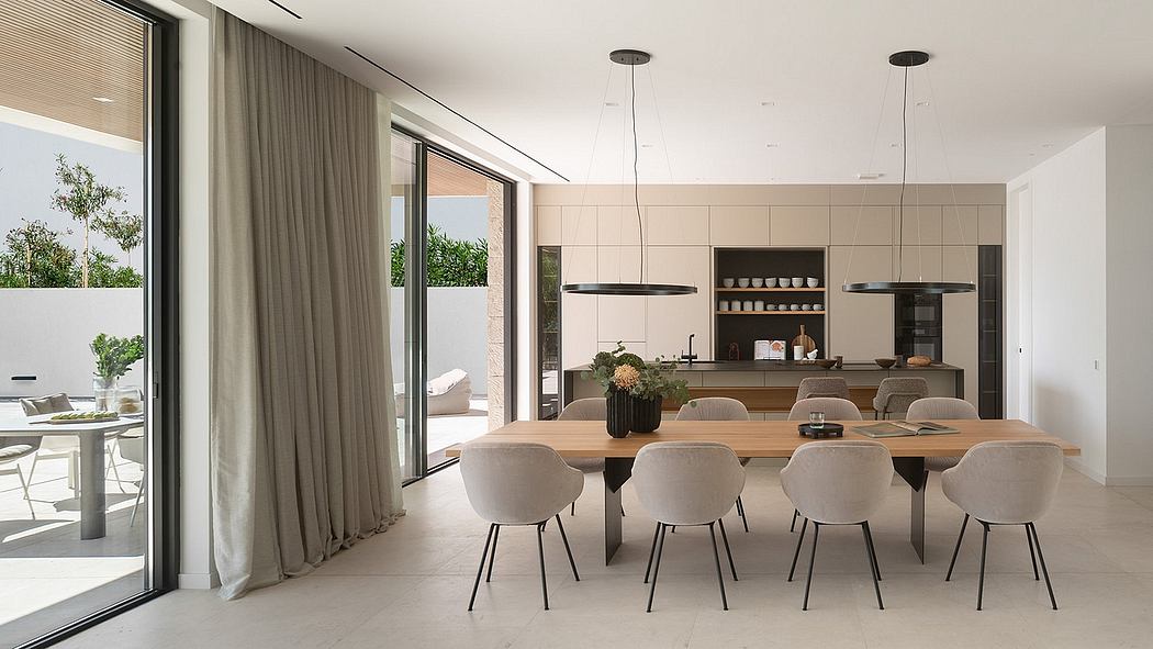 Bright, modern dining room with wooden table, pendant lights, and integrated kitchen.