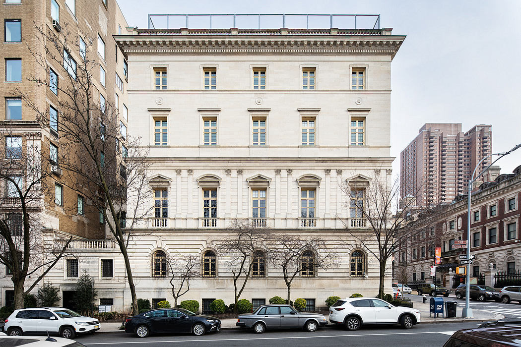 Elegant Beaux-Arts facade with ornate detailing and columns, set against modern city skyline.