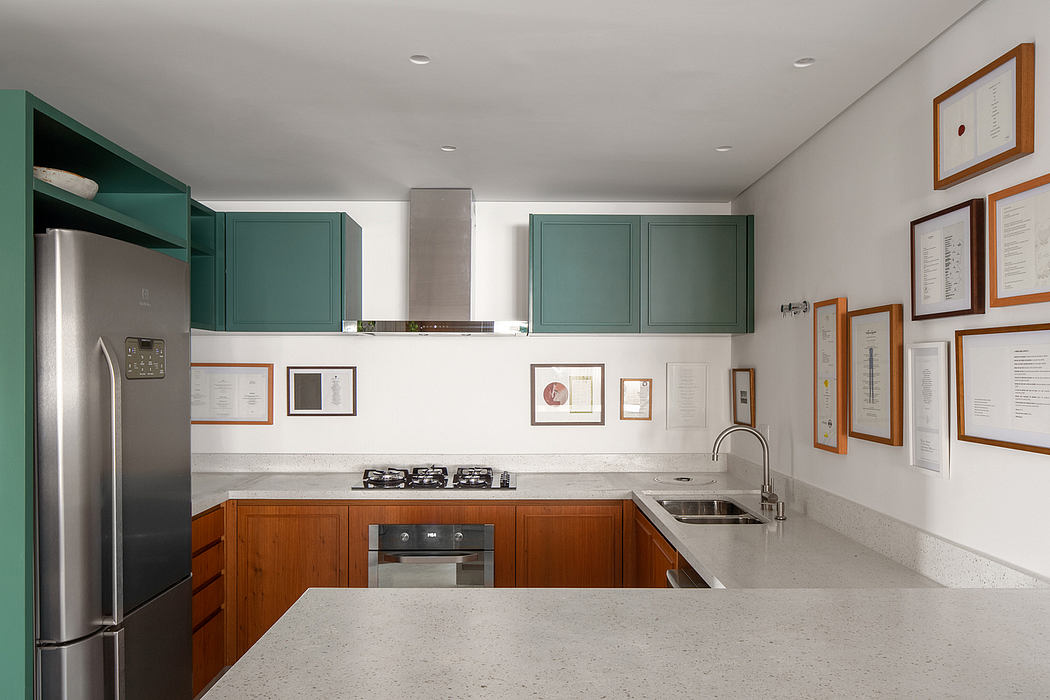 Sleek, modern kitchen with teal cabinets, wood accents, and framed certificates on wall.