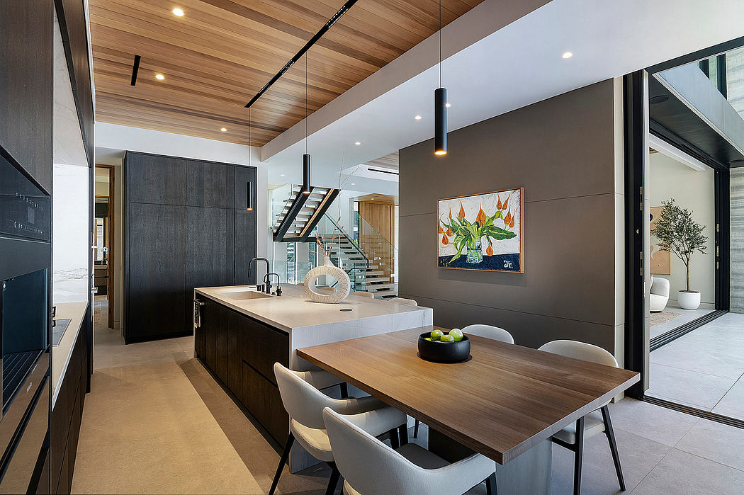 Spacious open-concept kitchen with wooden ceiling, modern appliances, and art piece.