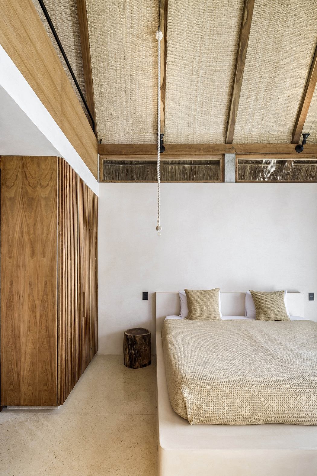 Minimalist bedroom design with wooden beams, rope lighting, and neutral tones.